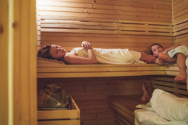 在芬兰火热的桑拿里 在木制长椅上躺着 汗流浃背 享受舒适的体温治疗 健康人民生活方式概念 — 图库照片