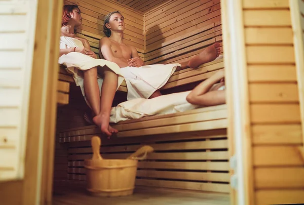 Casal Adolescentes Relaxantes Envolto Lençóis Brancos Deitados Suando Banco Madeira — Fotografia de Stock