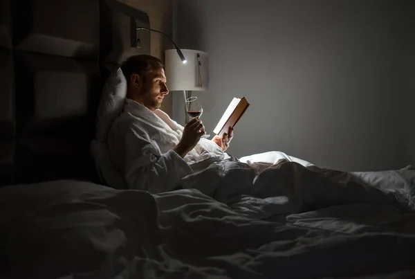 Homem Meia Idade Relaxante Rin Livro Leitura Cama Segurando Copo — Fotografia de Stock