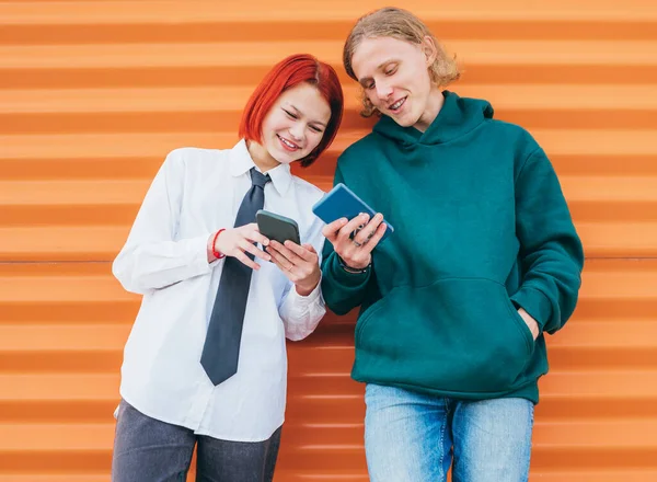Два Белых Друга Подростка Мальчик Девочка Просматривают Свои Смартфоны Опираясь — стоковое фото