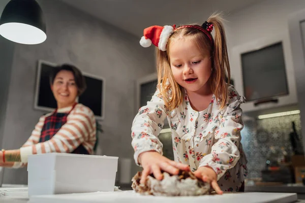 可爱的小女孩 留着两个可爱的马尾辫 戴着迷你红帽 和妈妈一起在家里厨房里揉搓圣诞姜饼面团 欢乐假期准备和童年概念 — 图库照片