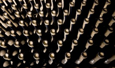 Şarap mahzeni, düşük hafif iç çekim. Şarap şişesi boyunlu, mantarlı arka planda şarap şişesi koleksiyonu olan. Para yatırımı ve şarap yapımı veya tüketim konsepti imajı.