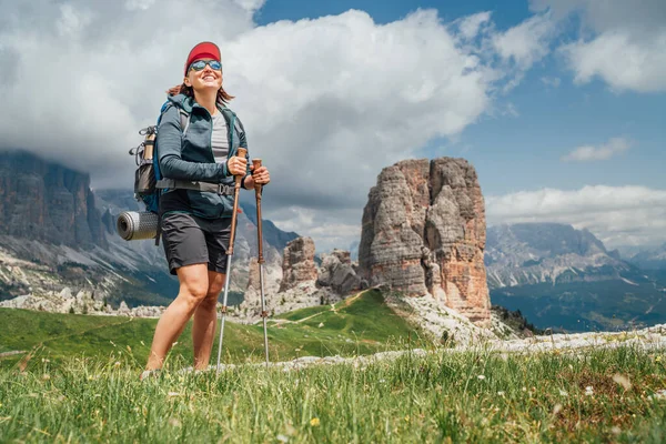Sırt Çantalı Gülümseyen Bayan Yürüyüşçü Yeşil Dağ Tepesinde Yürüyüş Direkleri — Stok fotoğraf