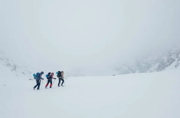 3人のメンバーロープチームは 高い山の冬のピークを登る ロムニッキー スティット ロッキー山脈の下にあるヴィソーク タトリー 高タトラ 山の構造盆地を覆うブリザード 極端なスポーツコンセプト — ストック写真
