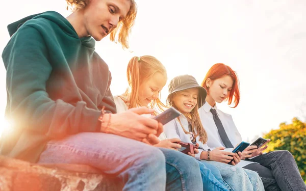 10代の男の子と妹の女の子は スマートフォンのデバイスを座って閲覧しています 不注意な若い十代の時間と近代的な技術の概念イメージ — ストック写真