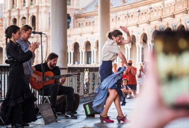 Seville, İspanya 11 Nisan 2023: Flamenko dansçısı kadın sokak müzisyenleri eşliğinde İspanya Meydanı, Endülüs, Güney İspanya 'daki Plaza de Espaa galerilerinde.