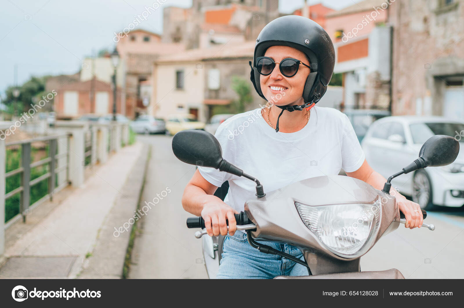 Smiling stylish girl in sunglasses sitting on moped and happily looking in  camera on street Stock Photo by garetsworkshop