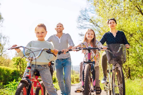 Sonriente Padre Madre Con Dos Hijas Durante Verano Montar Bicicleta —  Fotos de Stock