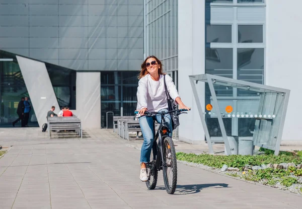 Щаслива Усміхнена Біла Жінка Вишуканих Сонцезахисних Окулярах Їде Велосипеді Сучасній — стокове фото