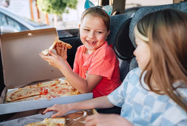 긍정적 미소를 자매가 뒷좌석에 어린이용 카시트에 요리한 이탈리아 피자를 아동기 — 스톡 사진