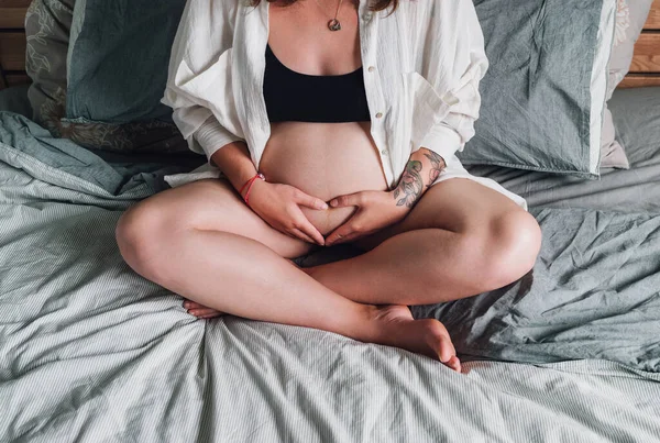 Young Pregnant Woman Tattooed Hand Sitting Cross Legged Tender Touching — Stock Photo, Image