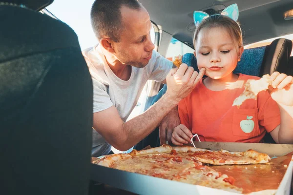 아버지는 가족용 자동차 브레이크 브레이크를 밟으면서 요리한 이탈리아 피자를 먹으면서 — 스톡 사진