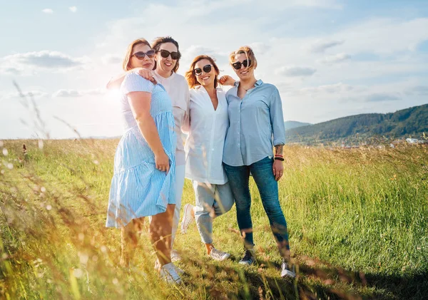 Yüksek Yeşil Çimen Tepesinde Yürürken Kucaklaşan Gülümseyen Dört Kadının Portresi — Stok fotoğraf