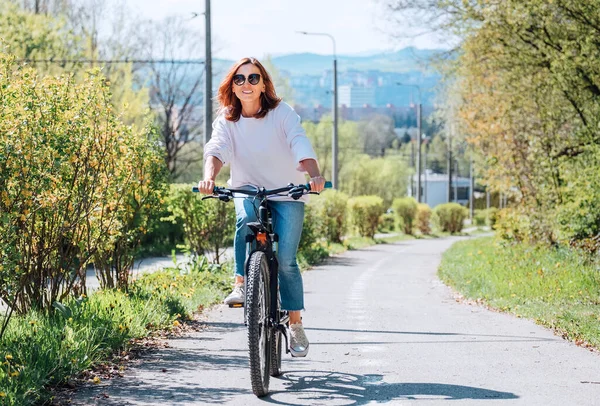 Szczęśliwa Uśmiechnięta Biała Kobieta Luksusowych Okularach Jeździ Rowerze Ulicy Miejskiego — Zdjęcie stockowe
