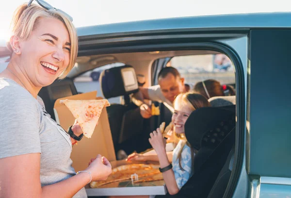 家族旅行が停止しながら ちょうど調理されたイタリアのピザのスライスと肯定的な笑顔の女性 幸せな家族の瞬間 子供時代 ファーストフード 家族の価値観や自動車旅行のランチ休憩のコンセプトイメージ — ストック写真