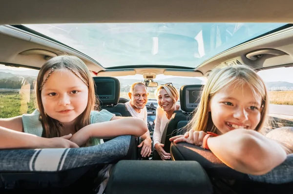 透明な屋根付きの現代車に座っている娘の肖像画を持つ若いカップル 幸せな家族の瞬間 子供時代 ファーストフードの食事やオートトラベルランチブレイクコンセプトイメージ — ストック写真