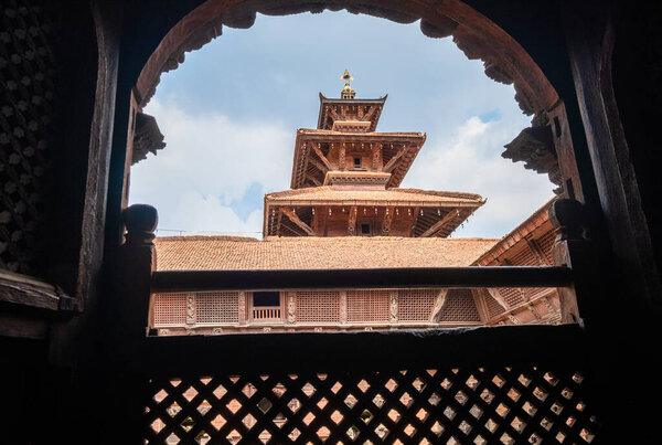 Real architecture masterpiece old temple view through the carved wood window, Patan Durbar Square royal medieval palace and UNESCO World Heritage Site. Lalitpur, Nepal.  