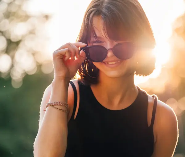 Schöne Junge Teenager Mädchen Mit Schicker Sonnenbrille Schwarzem Kleid Herausfordernd lizenzfreie Stockfotos