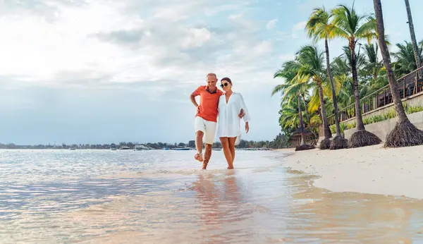砂のエキゾチックなビーチを歩いている間 愛の抱擁のカップル モーリシャス島のトゥルー ビッチズ海岸には夕方の散歩道があります 人々の関係と熱帯の新婚旅行の概念 ストック画像