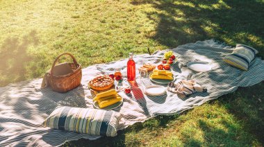 Haşlanmış mısırlı piknik battaniyesi, meyveler, sadece destekli turta, bir şişe meyve suyu, sepet, yaz parkında hayat. Kimse yok..