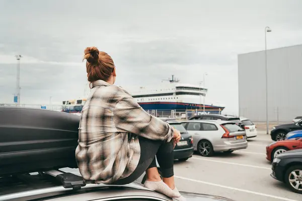 stock image Woman sitting on her car waiting the Norwegian ferry surrounded by other vehicles in background. Scene captures essence of relaxed travel, exploration in scenic Norwegian fjords