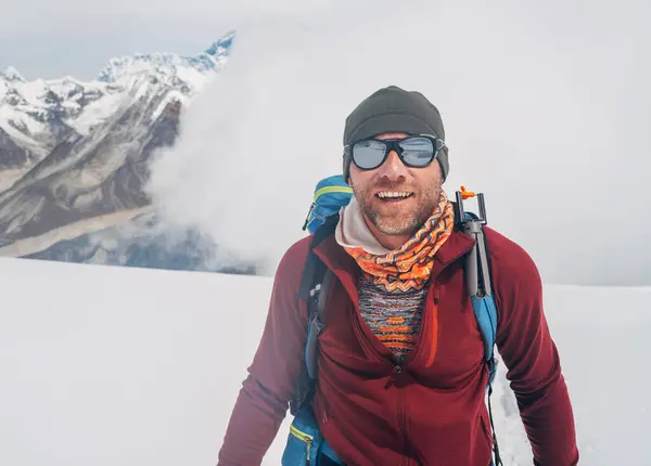 stock image Cheerful laughing climber in sunglasses portrait with backpack ascending Mera peak high slopes at 6000m enjoying legendary Mount Everest, Nuptse, Lhotse with South Face wall beautiful High Himalayas.