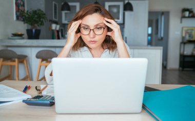 Güzel, orta yaşlı, gözlüklü, aylık faturaları olan, aile bütçesini düşünen bir kadın. Küçük işletme, ev ekonomisi, tasarruf konsepti imajı.