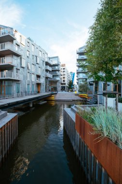 Oslo 'da modern, çağdaş bir caddenin samimi bir su kanalıyla çekilmiş görüntüleri. Gündüz vakti Norveç başkentinde yaz sahnesi