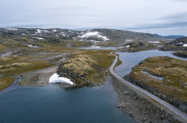Önde gelen yol Norveç 'in şiddetli Tundra doğası ve kuş manzarası vardı. Resimli kuzey Norveç manzarası ve modern otoyol yapımı havadan çekim. Rondane Ulusal Parkı, Norveç.