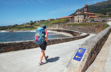Santiago de Compostela Katedrali ünlü Camino de Santiago ile birlikte İspanya 'nın Santiago de Compostela kentindeki Obradoiro meydanında oturan neşeli orta yaşlı gezgin kadın.