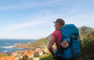 İspanyol Atlantik kıyısında Camino Portekiz Yolu 'nda sırt çantası taşıyan erkek hacı ile Marinas köyü manzarası gibi. Ünlü Camino de Santiago 'da ilham verici bir yürüyüş. Seyahat, hac, yaşam tarzı konsepti