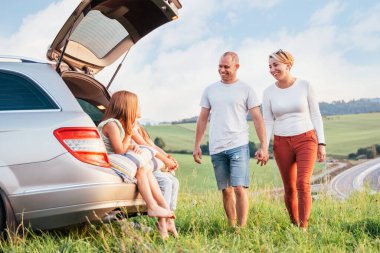 İki kız kardeş arabanın bagajında gün batımının tadını çıkarıyorlar. Kafkasyalı genç bir çift yeşil çim çayırında el ele yürürken araba tatili yapıyor. Aile değerleri, seyahat ve arkadaşlık kavramı.