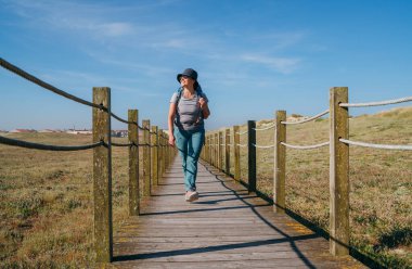Sırt çantalı orta yaşlı bir kadın Portekiz 'de Camino Portekiz' de yürüyor Santiago de Compostela 'ya giden popüler bir hac rotası. Aktif yaşam tarzı, seyahat ve mutluluk kavramı