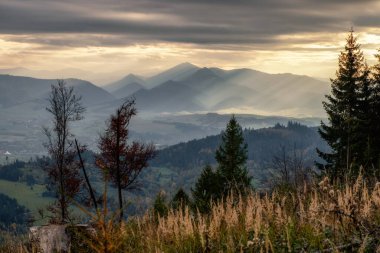 Kara bulutların arasından gün ışığı. Bulutlu güneş ışınları. Bulutlu gökyüzünde güneş ışığı.