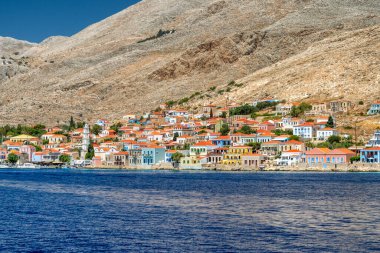Halki, Yunanistan - 6 Temmuz 2022: Yunanistan 'daki Dodecanese adalarının bir kısmı olan Ege Denizi' ndeki Halki (Chalki) küçük pitoresk adasında renkli evler