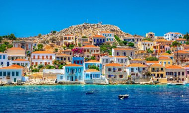 Halki, Yunanistan - 6 Temmuz 2022: Yunanistan 'daki Dodecanese adalarının bir kısmı olan Ege Denizi' ndeki Halki adasındaki küçük pitoresk adada renkli evler