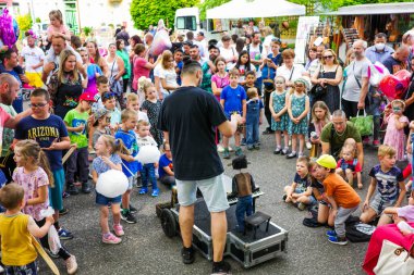 Ruzomberok, Slovakya - 3 Haziran 2022: Bir sokak sanatçısının kuklalarıyla gösteri arayan çocuklar