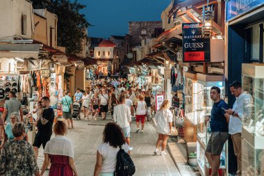 RHODES, GREECE - 4 Temmuz 2022: Yunanistan 'ın Rodos adasındaki Rodos şehrindeki eski Sokratous caddesinde yürüyen insanlar