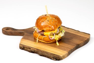 Tasty american burger on wooden serving board and white background.