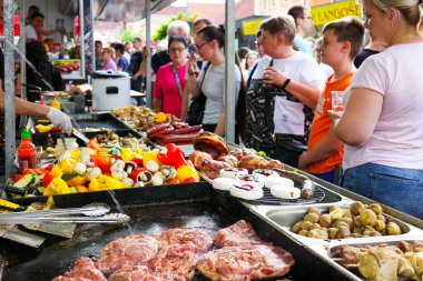 Ruzomberok, Slovakia - Jun 3, 2022:People looking on grilled meat at market with snack