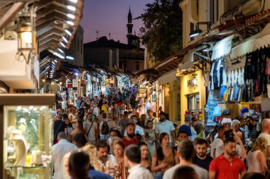 RHODES, GREECE - JULY 4, 2022: Crowded shopping street with souvenir shops in the old town of Rhodes city in Rhodes island in Greece
