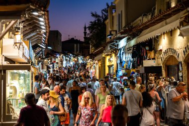 RHODES, GREECE - JULY 4, 2022: Many tourists walking through the shopping street in the old town of Rhodes city in Greece