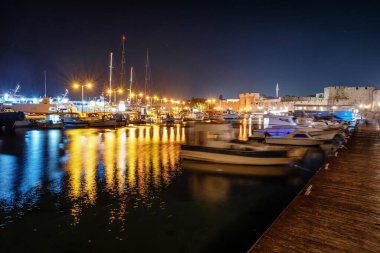 RHODES, GREECE - JULY 4, 2022: Boats under night sky in Kolona harbour in Rhodes city in Greece