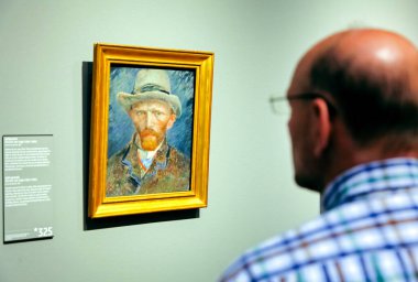 Amsterdam, Hollanda - 3 Nisan 2014: Amsterdam 'daki Rijksmuseum galerisinde Vincent Van Gogh' un ünlü oto-portresine bakan ziyaretçi