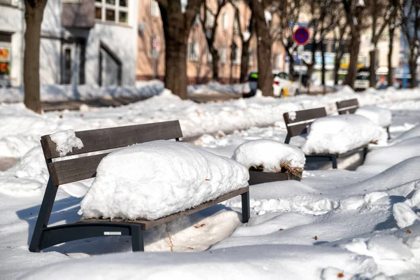 冬に雪に覆われた町のベンチ 街の冬の天気 — ストック写真