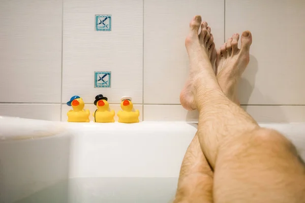 Nohy Muže Relaxující Vaně Žluté Kachny — Stock fotografie
