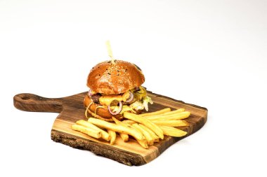 Tahta servis panosunda taze ev yapımı hamburger ve patates kızartması. Kopyalama alanı olan beyaz arkaplan.