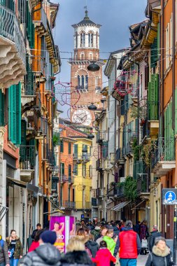 VERONA, İtalya - 10 Şubat 2018: Turist dolu yol ve Torre dei Lamberti arka planda