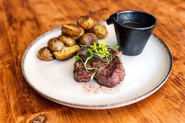 Masanın üzerinde patates ve taze biftek.