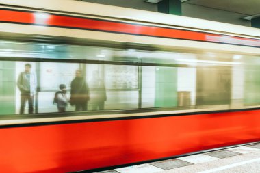 Berlin, Almanya - 6 Nisan 2017: Halk platformda duruyor ve Berlin 'deki metro istasyonuna gelen treni bulanıklaştırıyor